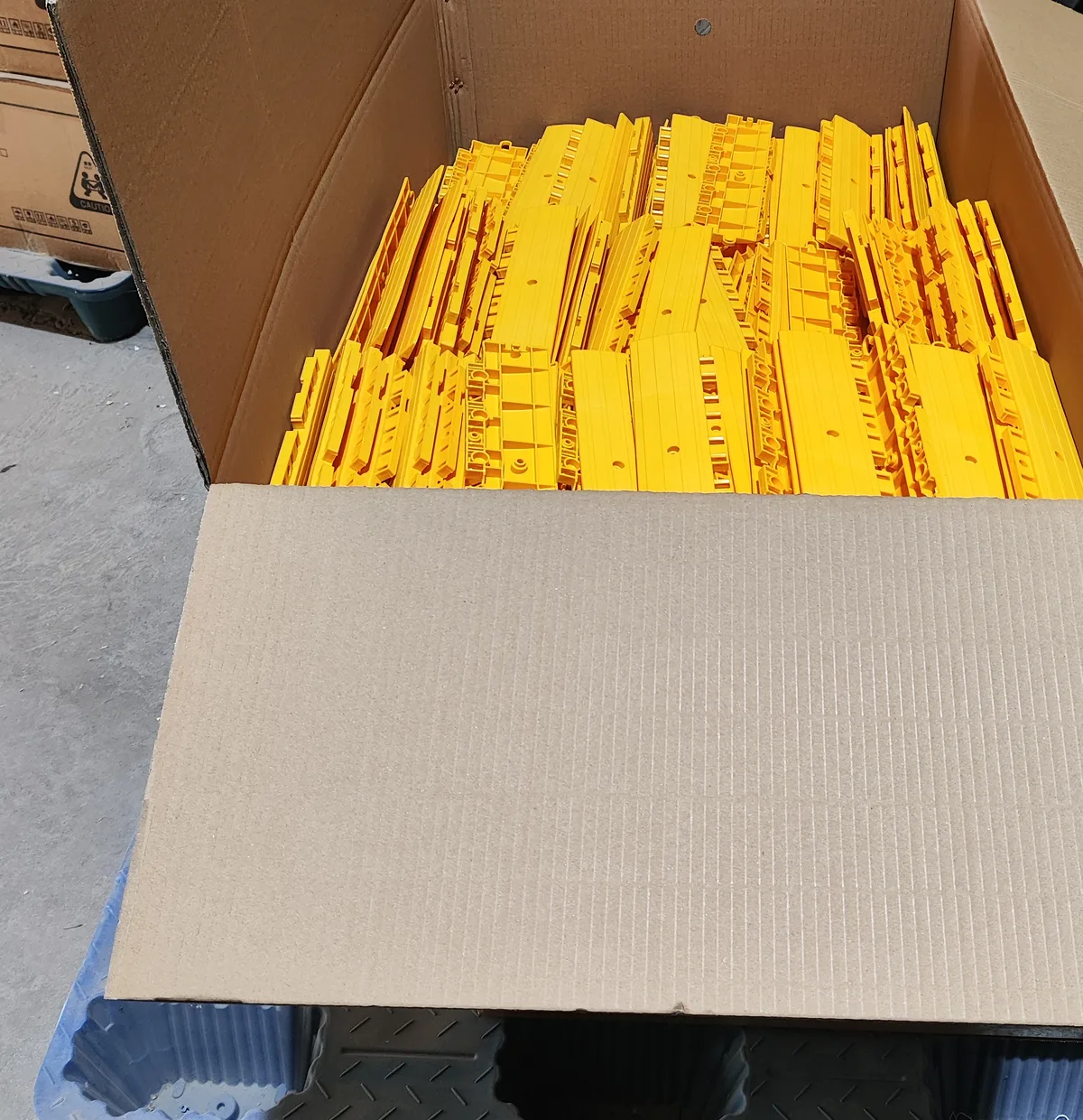 Yellow modular sports tiles packed in a protective carton